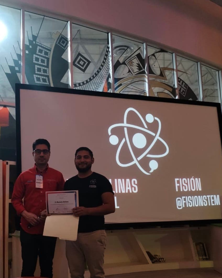 Ramses receiving a Fisión recognition in front of the @fisionstem logo.