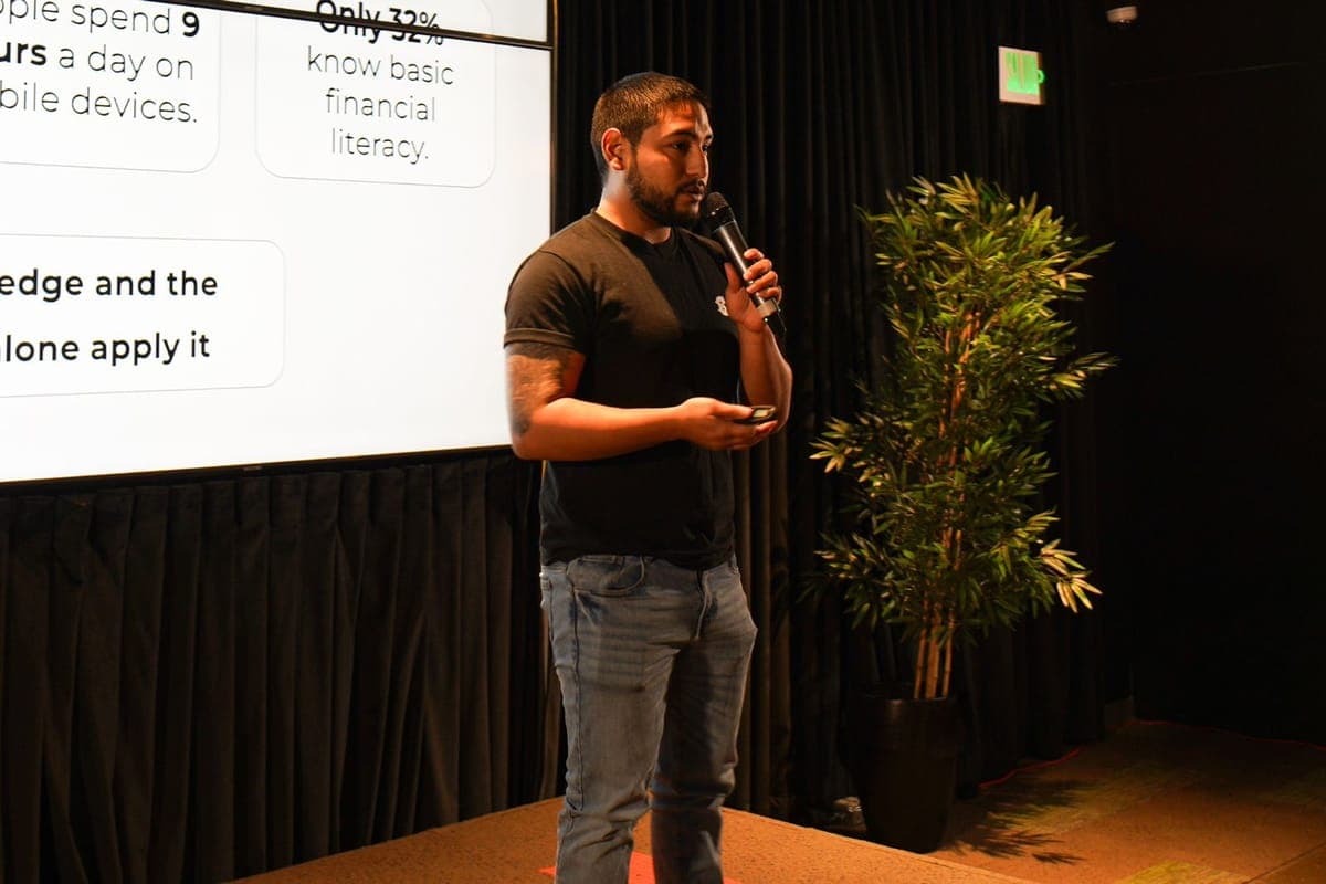 Ramses speaking with a microphone at Fisión's 'Cómo no apestar al hablar en público' workshop.