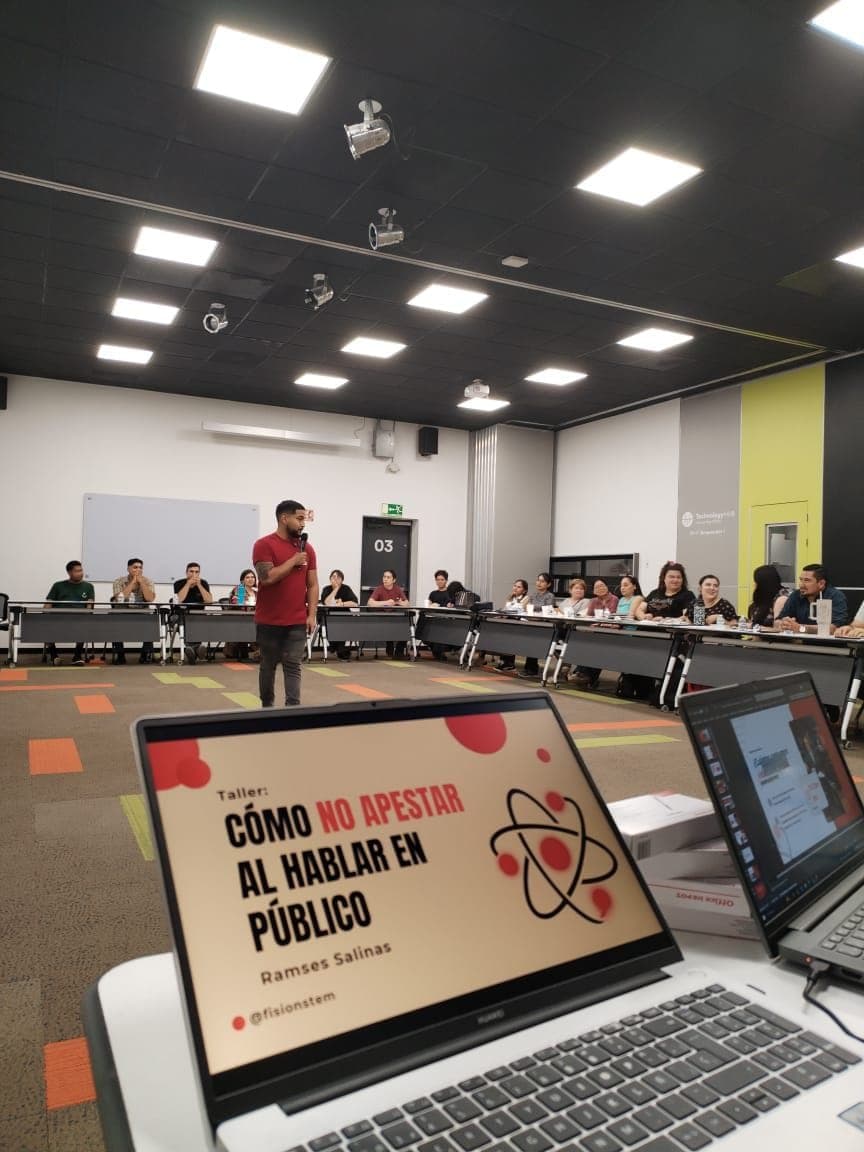 Ramses speaking with a microphone at Fisión's 'Cómo no apestar al hablar en público' workshop.