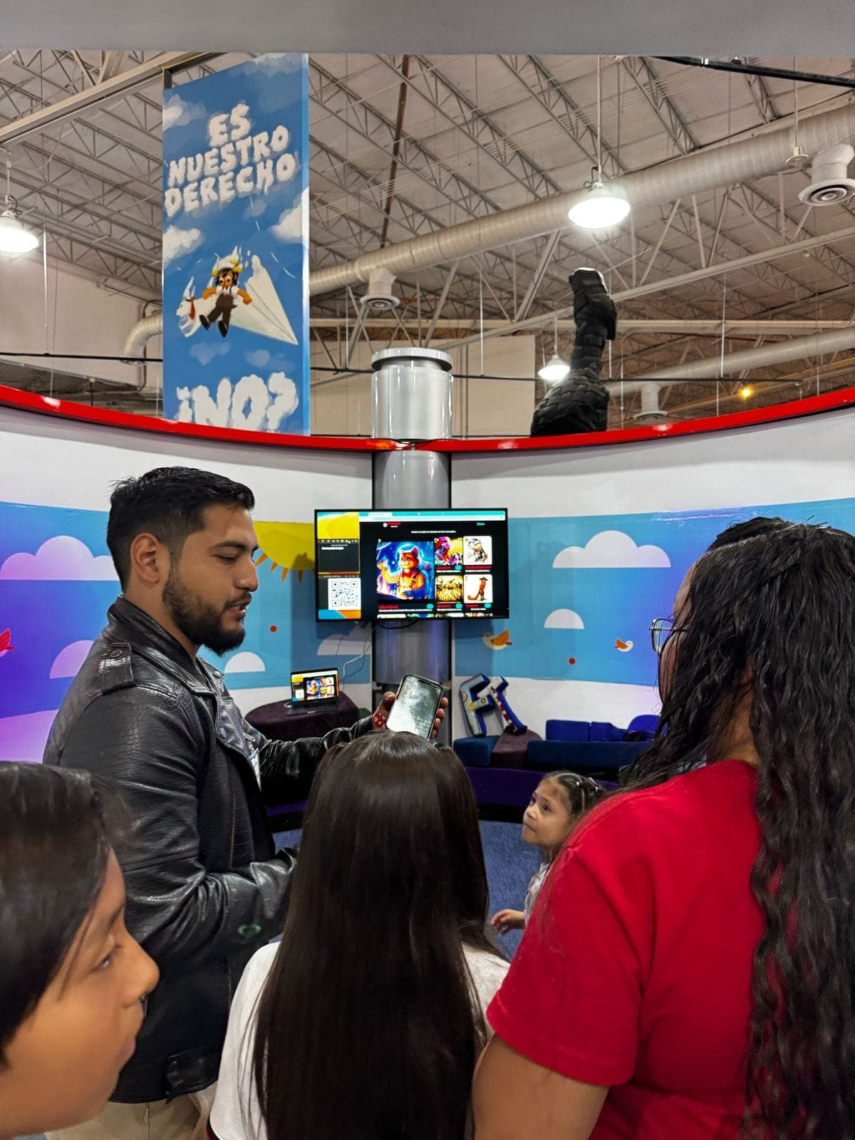 Ramses showing content to a group of kids at the 'Es Nuestro Derecho' exhibit.