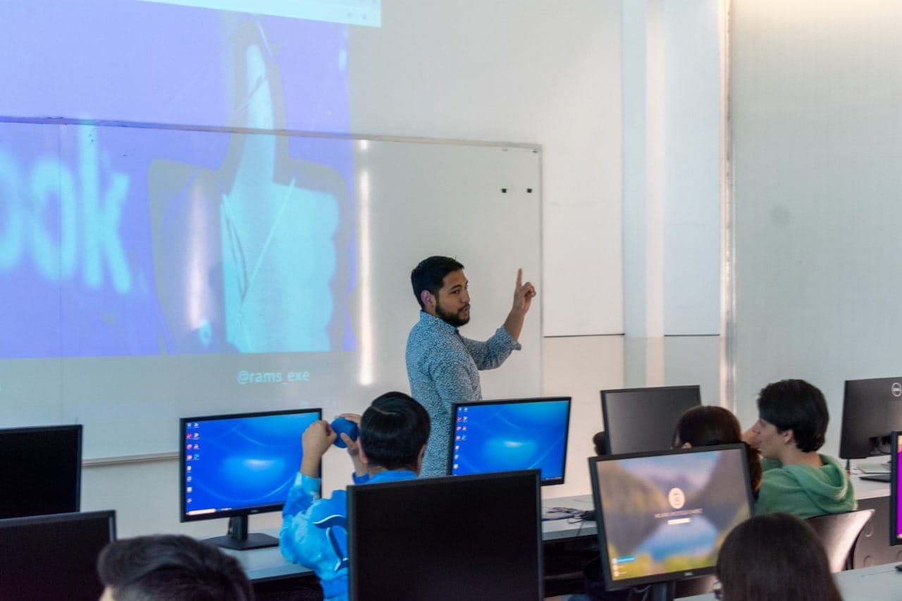 Ramses teaching a class of students in a room full of computers.